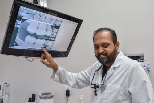 Dentist showing a patient their x-rays before getting a dental bridge